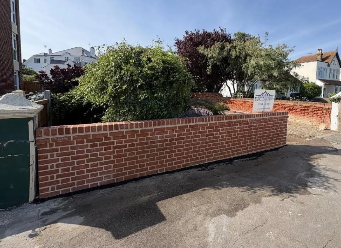 After: completed red-brick boundary wall with brick-on-edge coping