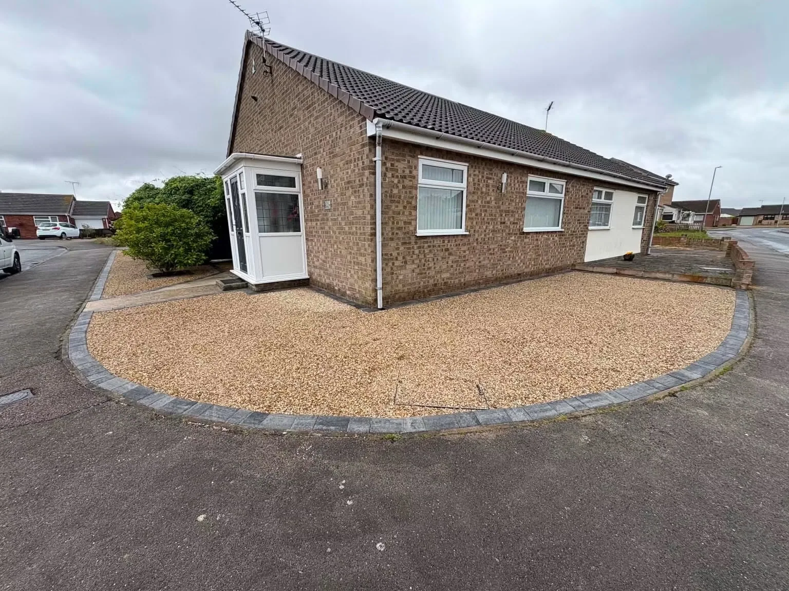 After: completed golden gravel and charcoal edging beside the boundary wall