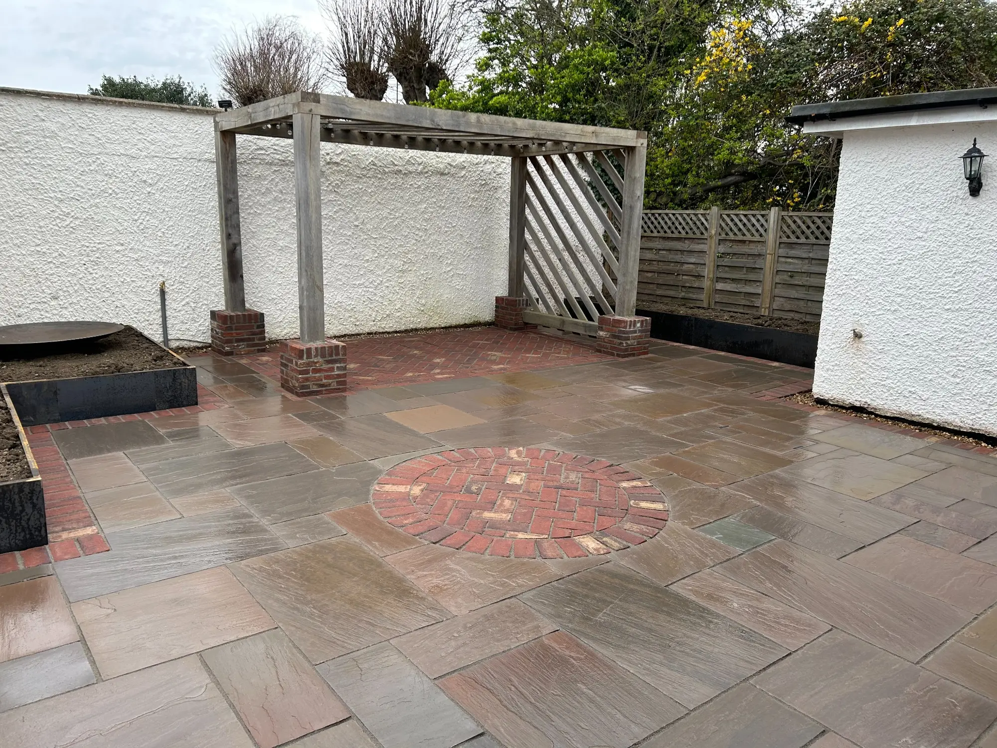 Completed patio with raised planters and detailed brickwork